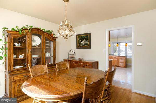 8011 Langbrook Road Springfield, VA 22152 - Photo 9 of 30 a dining room with furniture a chandelier and wooden floor