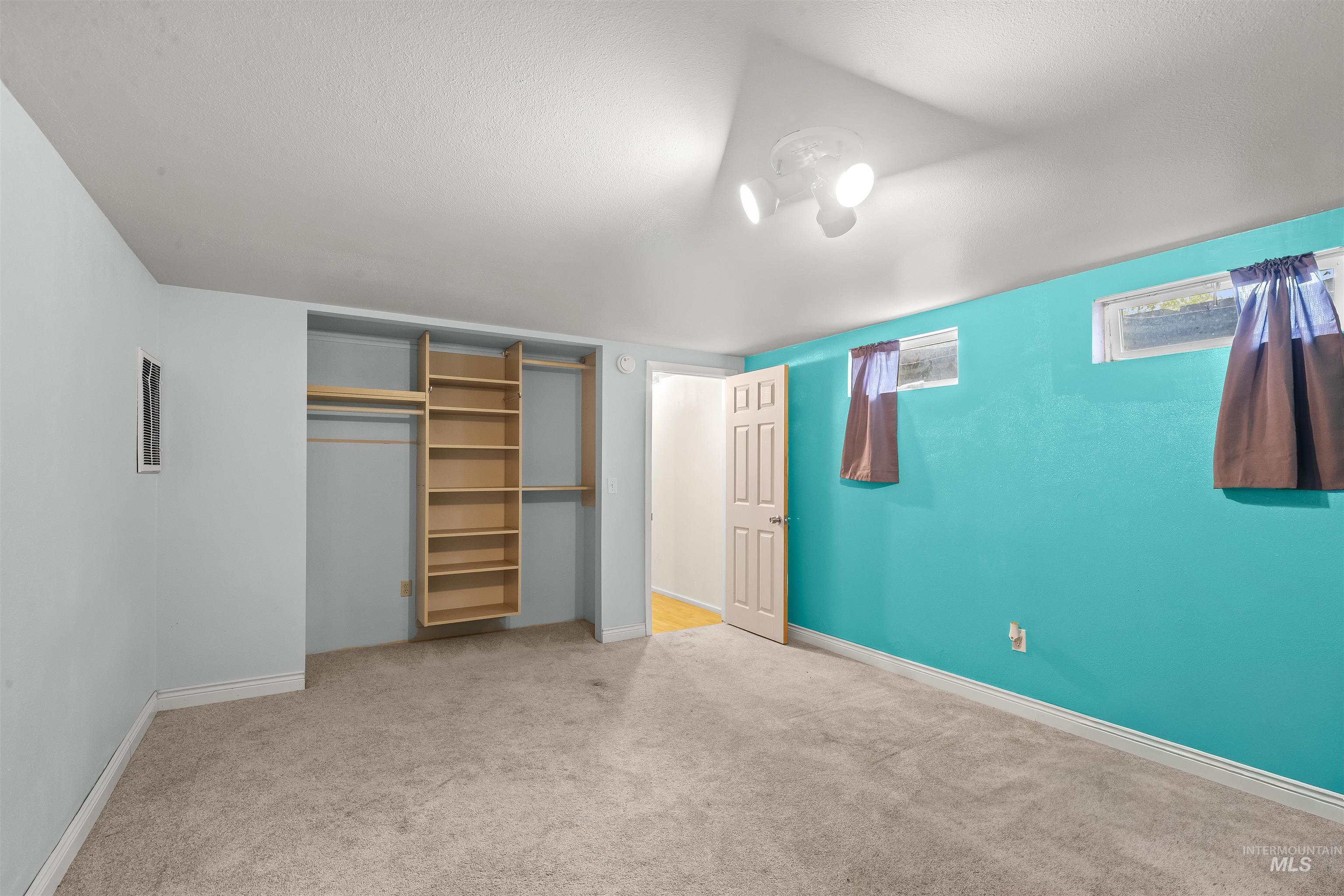 3620 18th Street Lewiston, ID 83501 - Photo 19 of 32 Carpeted room featuring a built-in closet system with shelving and hanging rods, recessed windows, a ceiling-mounted light fixture, and a solid interior door