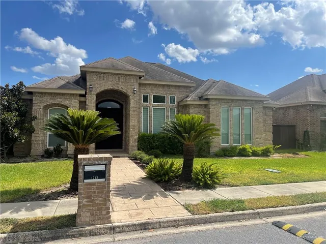 a front view of a house with a garden and yard