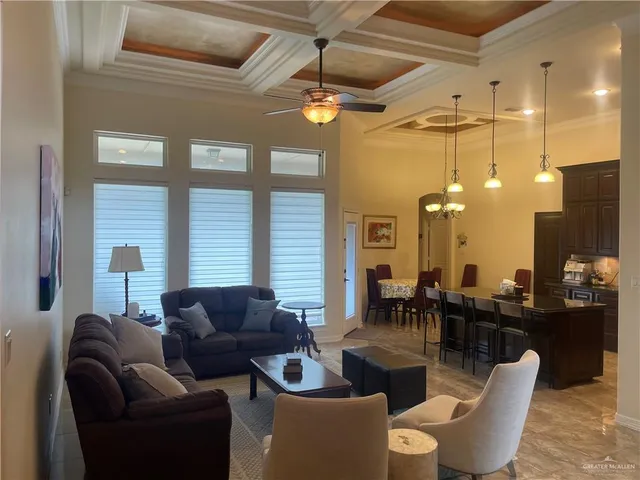 a living room with furniture a chandelier and a large window