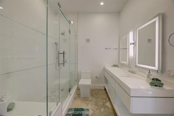 a bathroom with a double vanity sink toilet and shower