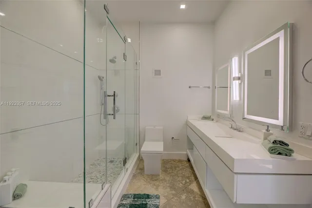 a bathroom with a double vanity sink toilet and shower