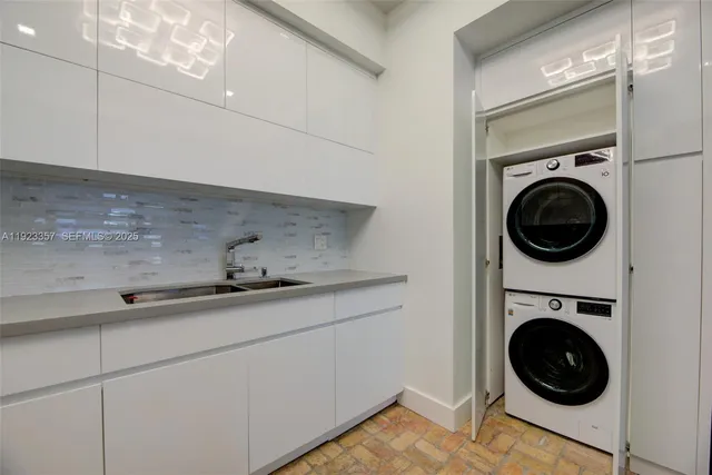 a utility room with sink dryer and washer