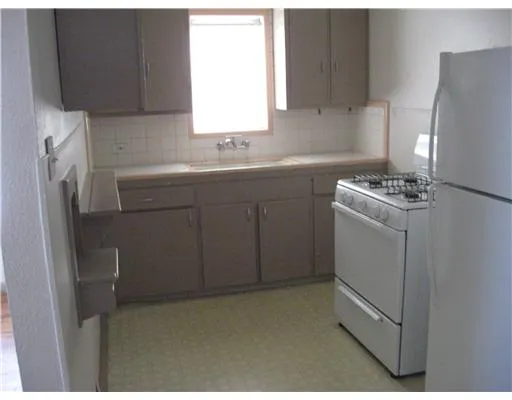 a kitchen with cabinets appliances and a window
