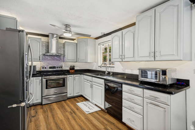 1215 8th Street Ogden, UT 84404 - Photo 10 of 39 Kitchen featuring wood-finish flooring, light-toned cabinetry, dark countertops, a stainless steel range with a ventilation hood, and a ceiling fan