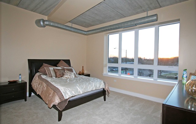 450 Village Center Drive, Unit 305 Burr Ridge, IL 60527 - Photo 7 of 10 a bedroom with a bed and a large window
