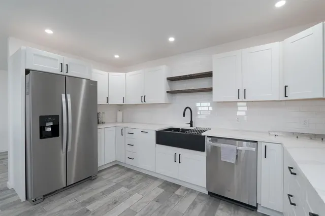 a kitchen with white cabinets and stainless steel appliances