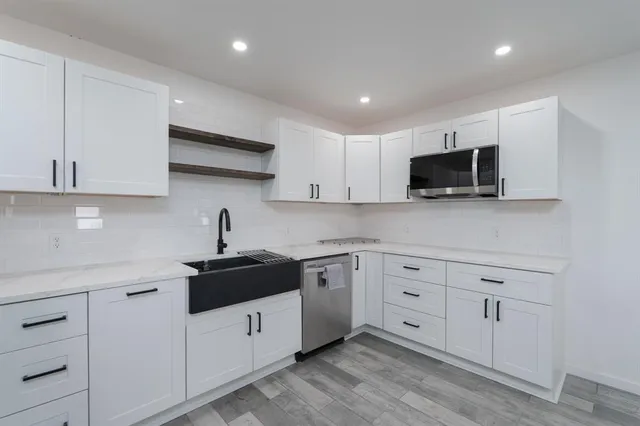 a kitchen with white cabinets stainless steel appliances and sink