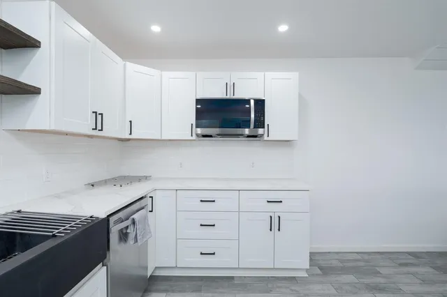 a kitchen with white cabinets and stainless steel appliances