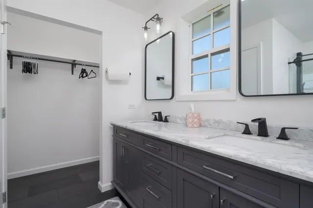a bathroom with a granite countertop sink and a mirror