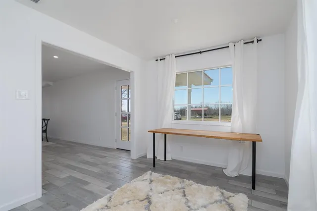 an empty room with window and a wooden floor