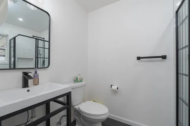 a bathroom with a toilet a sink and mirror