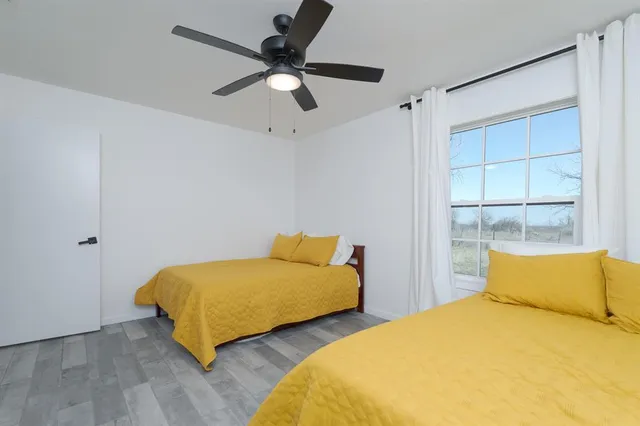 a bedroom with 2 bed and window