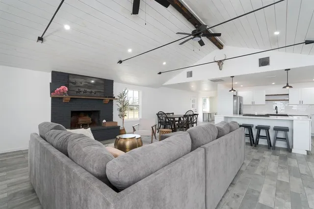 a living room with furniture a fireplace and a flat screen tv
