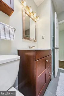 a bathroom with a sink a toilet a mirror and shower