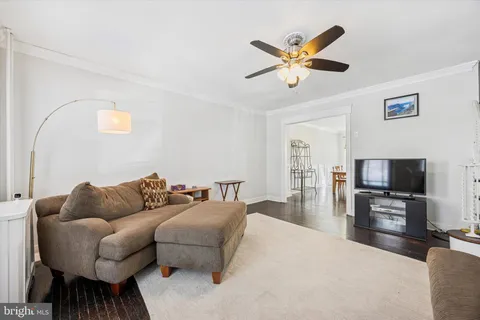 a living room with furniture and a flat screen tv with wooden floor