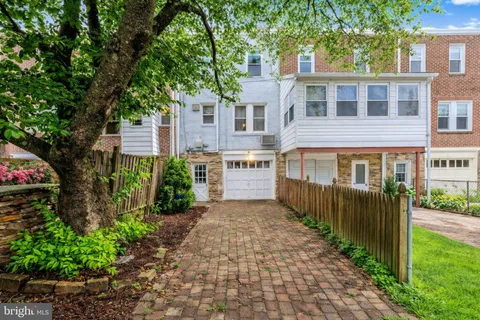 a front view of a house with a yard and potted plants