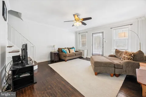 a living room with furniture a ceiling fan and a window