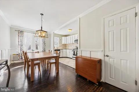 a view of a dining room and livingroom with furniture wooden floor a chandelier