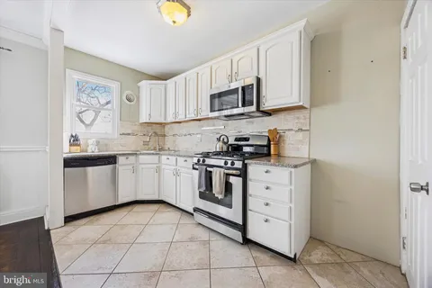 a kitchen with stainless steel appliances white cabinets and a stove