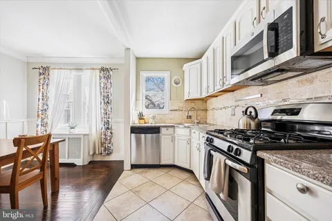 a kitchen with stainless steel appliances granite countertop a stove and a white cabinets