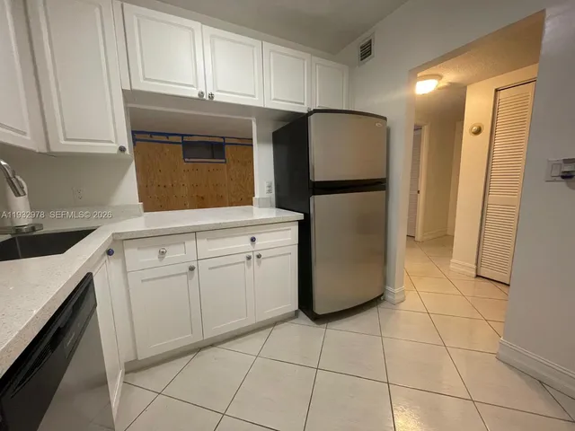 a kitchen with a refrigerator sink and cabinets