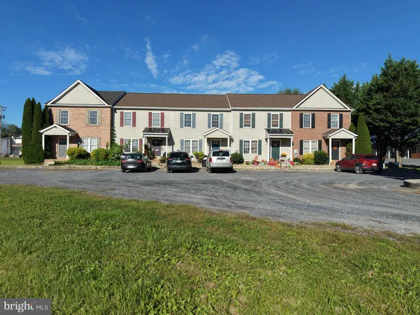 a front view of a residential houses with yard and green space