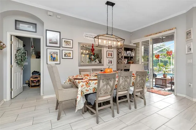 a large kitchen with stainless steel appliances kitchen island granite countertop a table chairs and a refrigerator