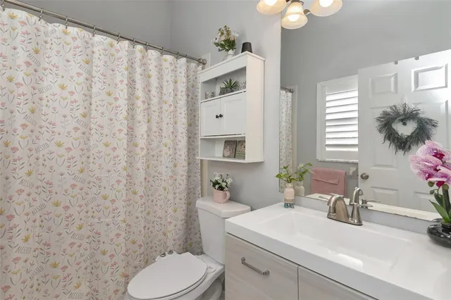 a spacious bedroom with a bed window and flat screen tv