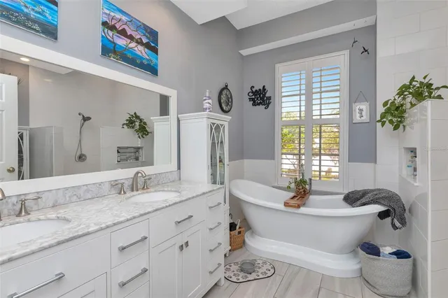 a bedroom with a bed a flat screen tv and a window