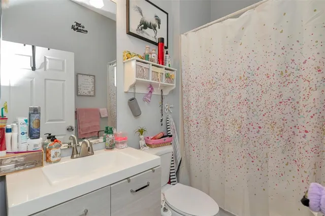 a bedroom with a bed and a flat tv screen on dresser