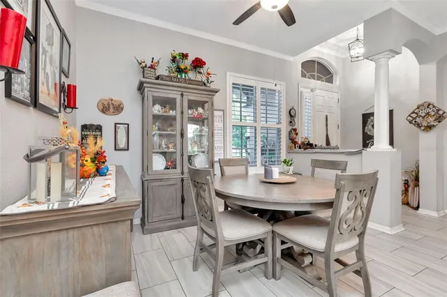 a dining room with furniture a chandelier and kitchen view