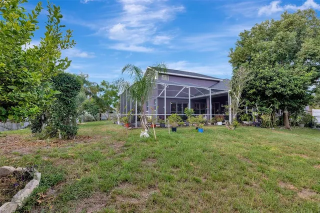 a view of a house with a yard and potted plants