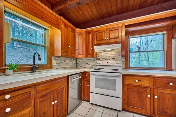 a kitchen with granite countertop stainless steel appliances sink stove and cabinets
