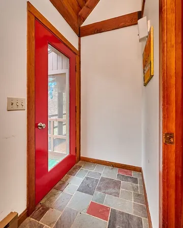 a view of an empty room with wooden floor and a fireplace