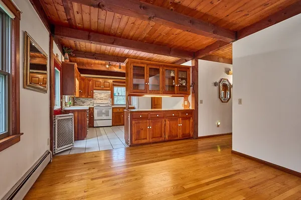 a room with stainless steel appliances wooden floors and wooden cabinets