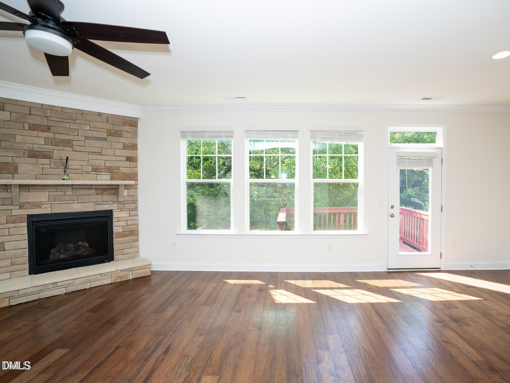 647 Newlyn Drive Raleigh, NC 27606 - Photo 11 of 53 an empty room with wooden floor fireplace and windows