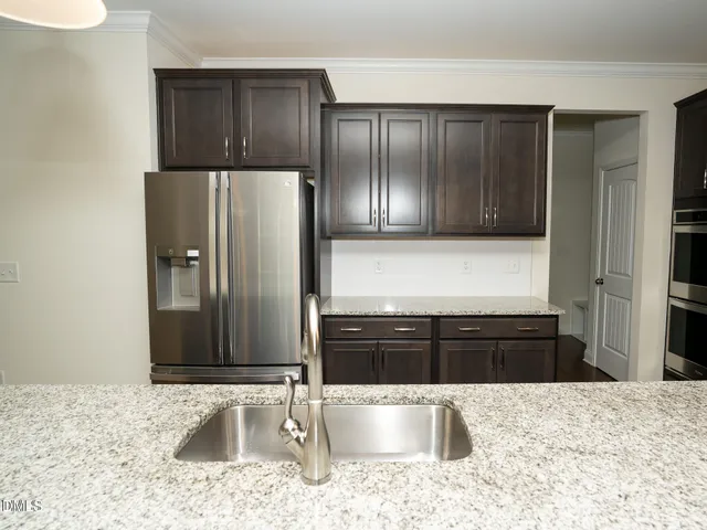 a kitchen with stainless steel appliances granite countertop a sink a stove and a refrigerator