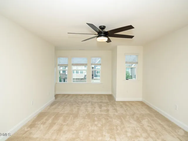an empty room with a window and a fan