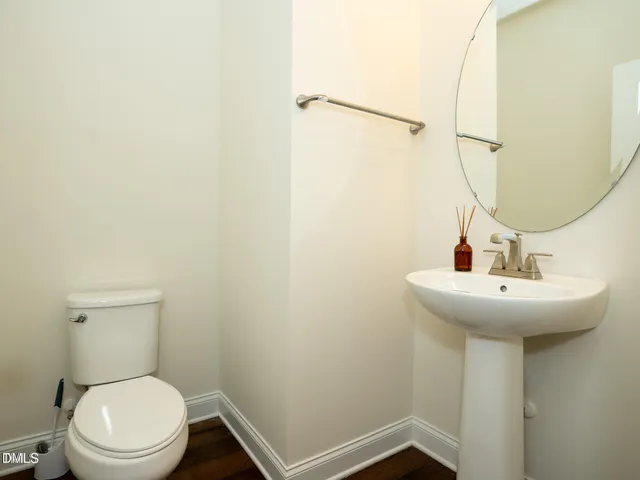an empty room with wooden floor fireplace and windows
