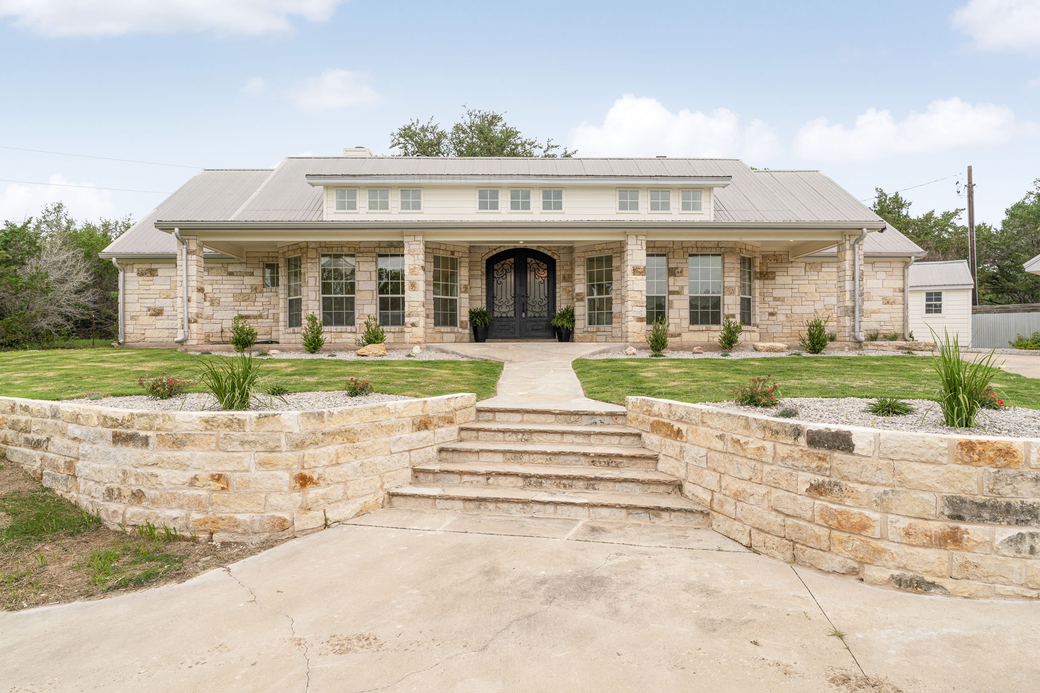 1129 Cedar Pass Road Driftwood, TX 78619 - Photo 2 of 40 Notice the clerestory windows above the porch—they flood the interior with natural light.