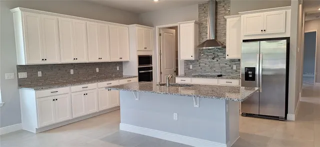 a kitchen with granite countertop a sink stainless steel appliances and cabinets