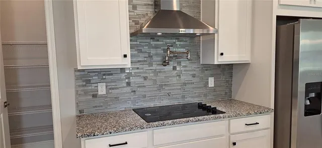 a kitchen with granite countertop a sink and a stove