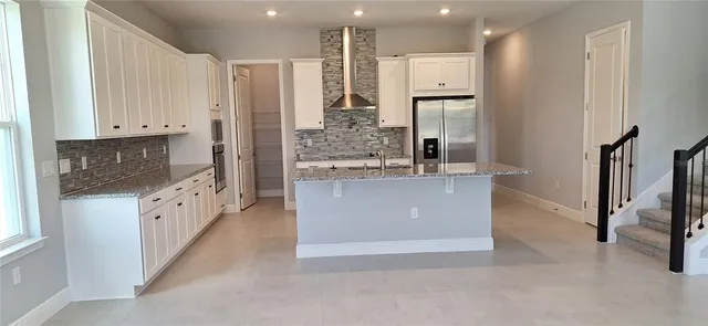a large white kitchen with stainless steel appliances