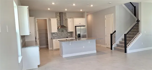 a large white kitchen with a refrigerator a sink and a stove