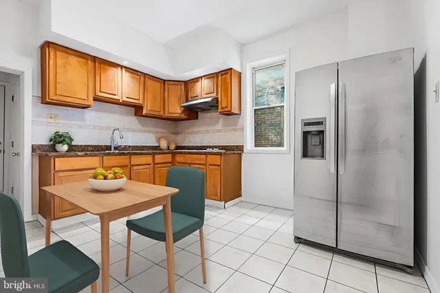 a kitchen with stainless steel appliances granite countertop a refrigerator and a stove top oven