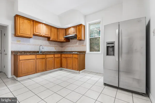 a kitchen with stainless steel appliances granite countertop a refrigerator a sink and a stove