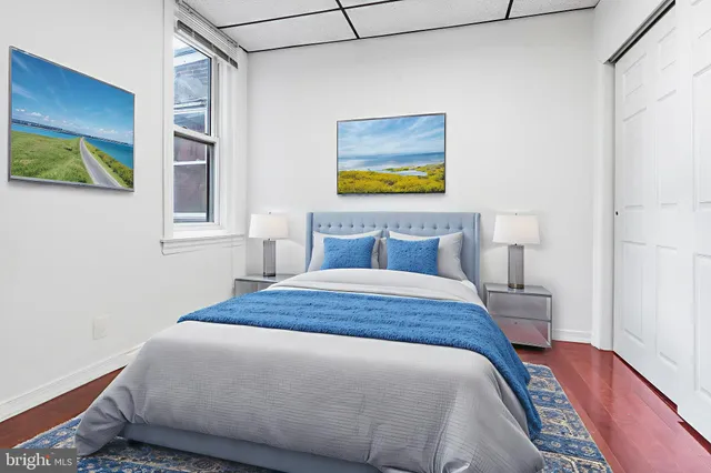 a bedroom with a bed and painting on the wall