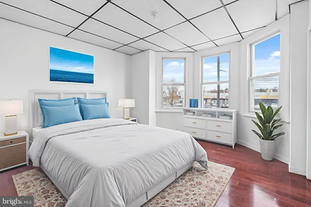 a bedroom with a large bed and a potted plant