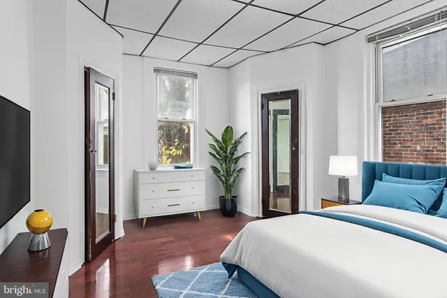 a bedroom with a bed and a potted plant